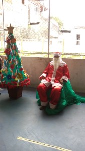 FOTO: Papai Noel ao centro, ao  lado esquerdo  uma Árvore de Natal